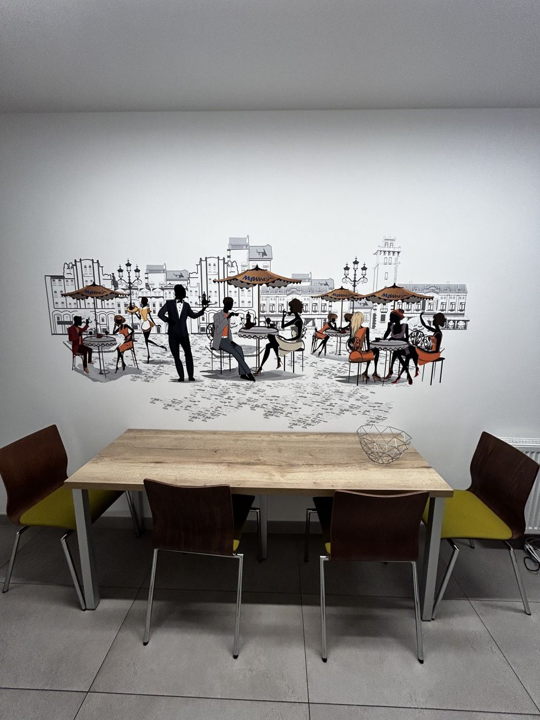 Sala spotkań z grafiką kawiarnianej uliczki na ścianie nad stołem
